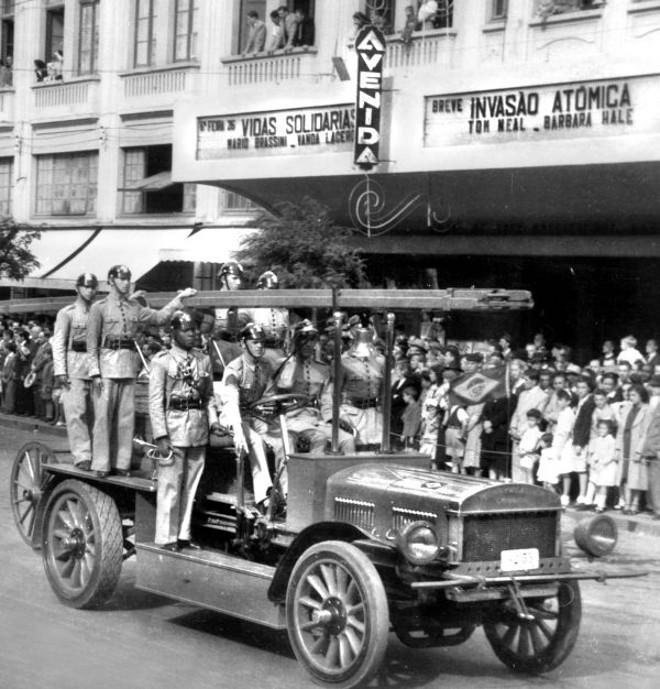O Corpo de Bombeiros desfila, em abril de 1946, com uma de suas viaturas históricas. Casando tal veículo estranho com o filme em cartaz no Cine Avenida: Invasão Atômica | 