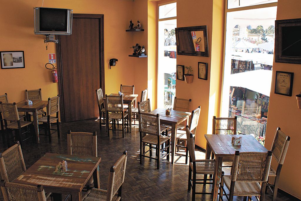 O ambiente acolhedor se revela nos móveis feitos com material reciclável e nos imensos janelões que dão para o Relógio das Flores | Fotos: Divulgação