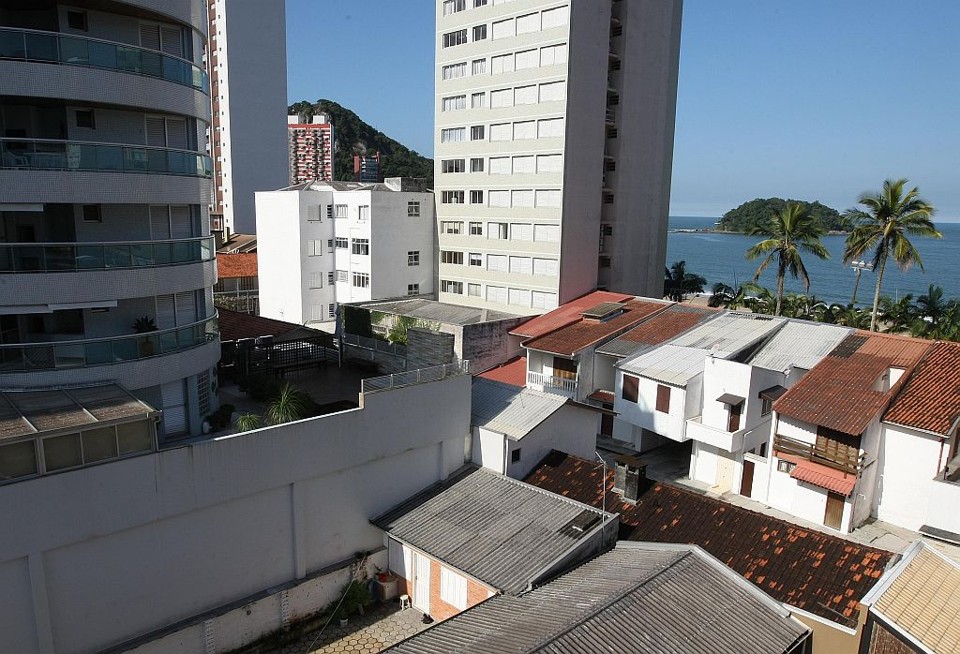 Vista da pequena casa (em primeiro plano, ao lado do muro), aos fundos de uma residência, em que Paulo Unfried morava antes de ser preso: 300 metros do Morro do Boi, entre os prédios | Jonathan Campos/Gazeta do Povo