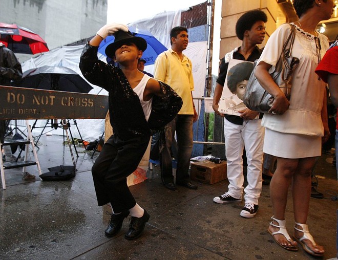Menino ensaia passos do ídolo Michael Jackson na entrada do Teatro Apollo em Nova Iorque | 