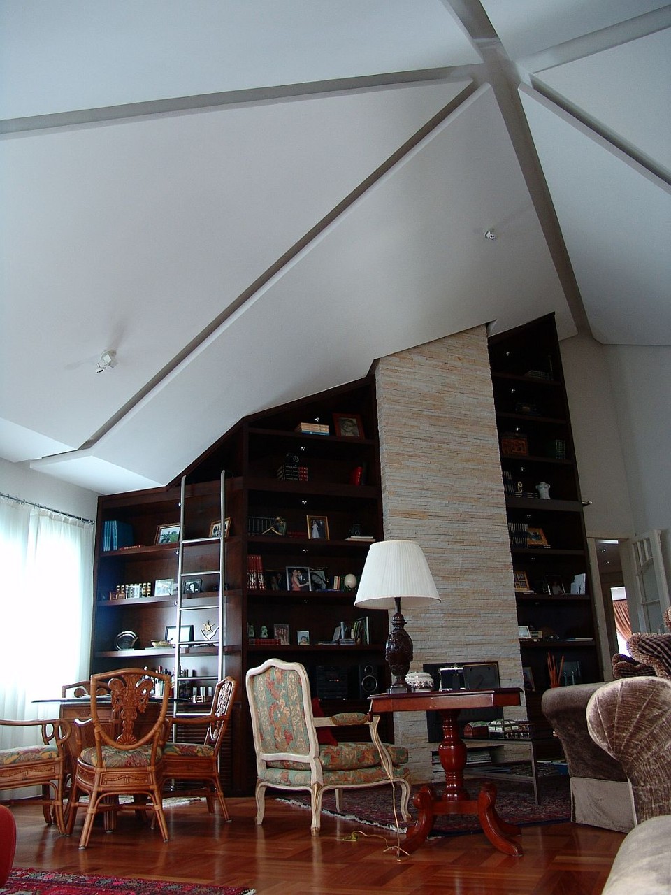 Mais de cinco metros de pé-direito e móveis adaptados para valorizar o caimento do telhado deu sofisticação ao projeto de Alessandra Gonçalves | Divulgação