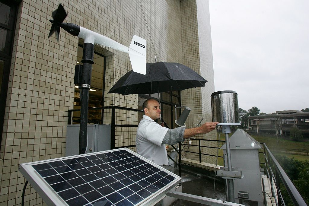 O meteorologista Pedro Costa confere o pluviômetro, um dos muitos aparelhos usados para medições externas do clima | Daniel Castellano/Gazeta do Povo