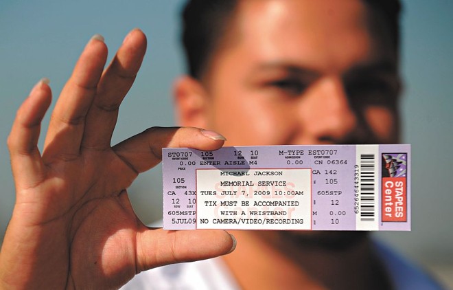 Mynar Garcia, morador de São Barnadino, na California, mostra seu ingresso para assistir à homenagem ao cantor Michael Jackson, que acontece hoje no Staples Center, em Los Angeles | Gabriel Bouys/AFP
