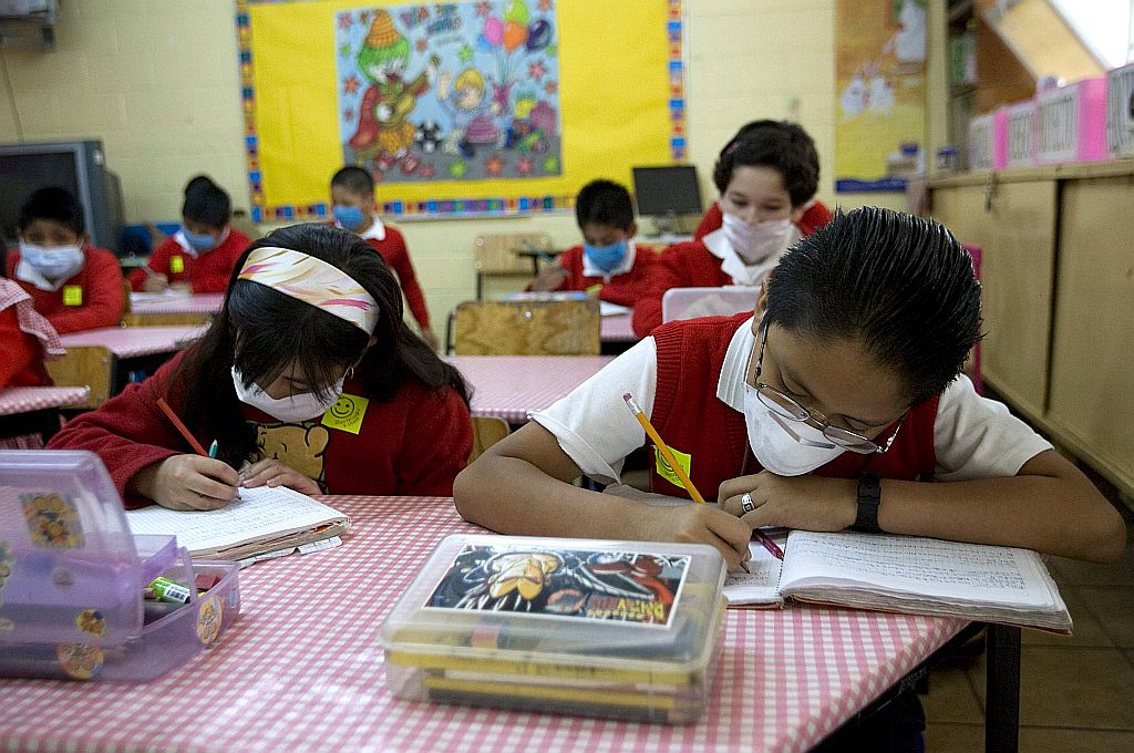 Crianças usam máscaras em escolas do México: gripe A matou 142 pessoas no país, epicentro da pandemia | Jorge Dan /Reuters