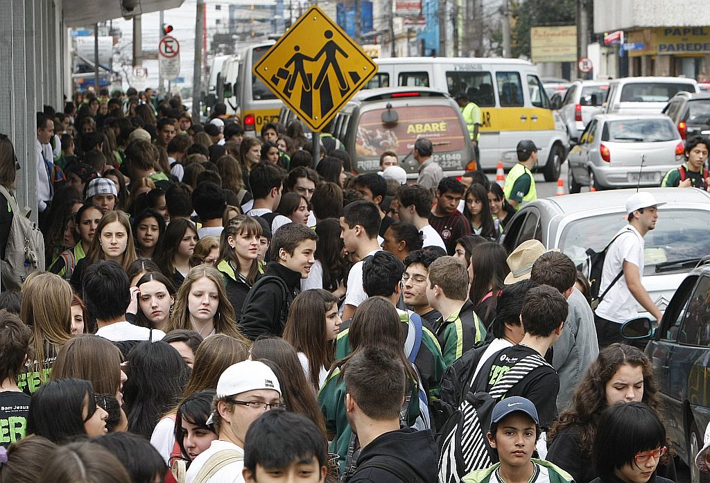 Aglomeração de alunos em frente a colégio particular de Curitiba, ontem pela manhã: recomendação é de evitar beijos e abraços nos colegas | Marcelo Elias/Gazeta do Povo