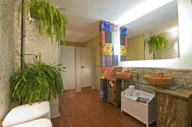 No ambiente, projetado pela arquiteta Marina Rodrigues, o tecido chita reveste uma das paredes. Em outra, foram cacos de azulejo. Um painel com tubos de pasta de dente foi usado na bancada da pia, que recebeu cuba em cerâmica |