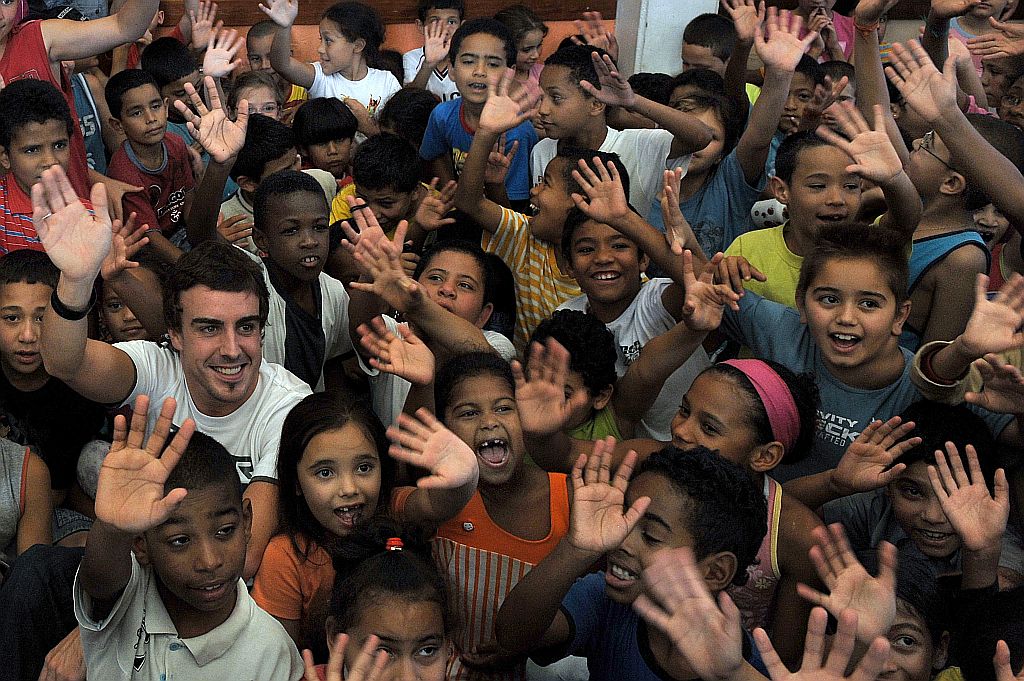 Fernando Alonso, da Renault, durante visita à escola Oscar Romero, no Jardim Santa Lúcia, bairro pobre de São Paulo | Mauricio Lima/AFP