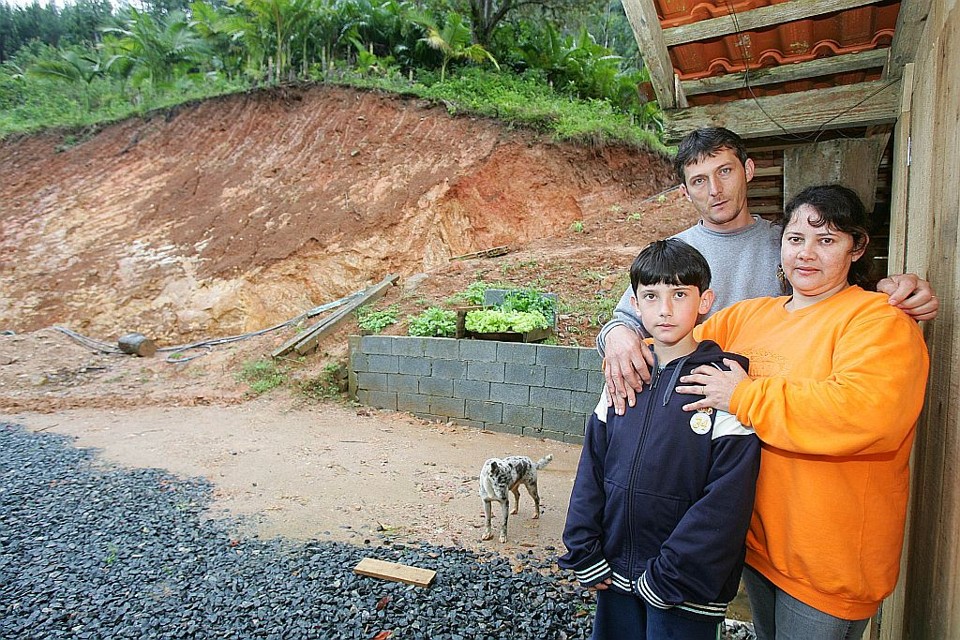 Marcos, Maria Leda e o filho Marcos Paulo: ameaça de desmoronamento de morro vizinho é risco constante | Daniel Castellano/Gazeta do Povo