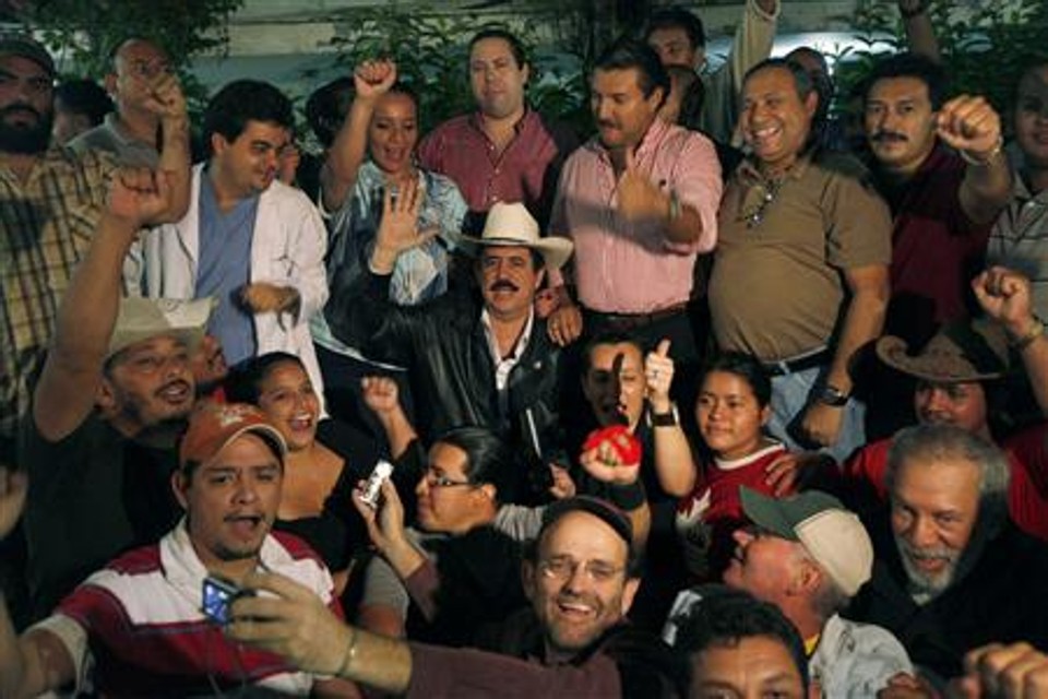 O presidente deposto de Honduras, Manuel Zelaya, posa com simpatizantes na embaixada brasileira em Honduras | Edgar Garrido/Reuters
