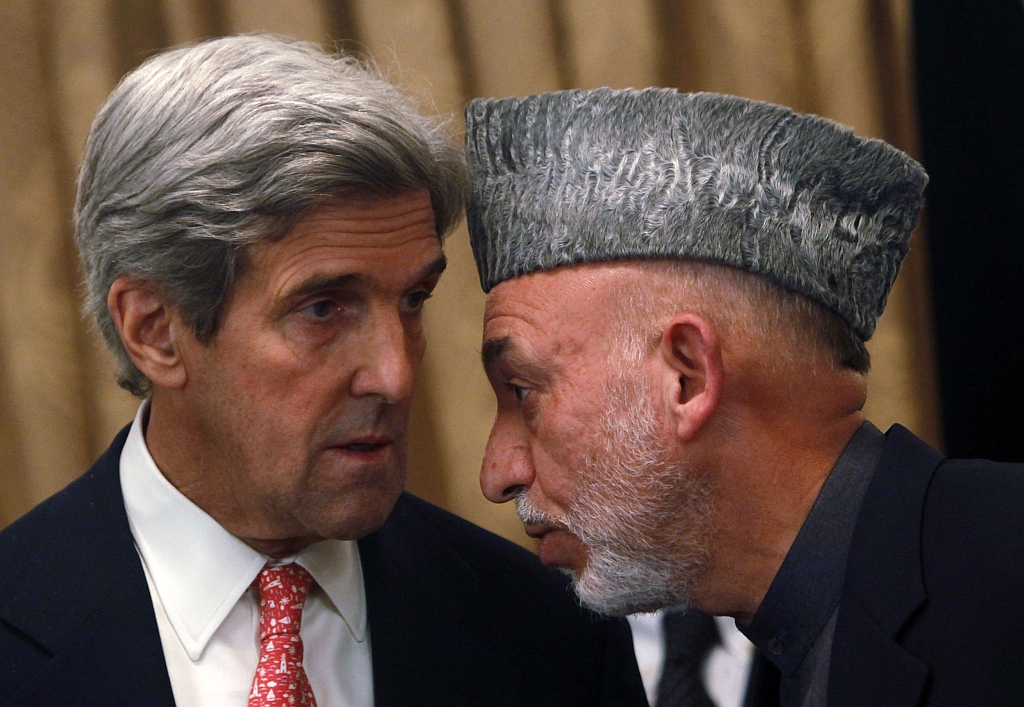 Presidente afegão que fraudou as eleições, Hamid Karzai (direita) com o senador americano John Kerry, em Cabul | Reuters