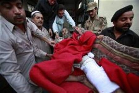 Soldado, policial e funcionários do hospital carregam homem ferido em ataque contra um comboio militar paquistanês nesta segunda-feira | Reuters