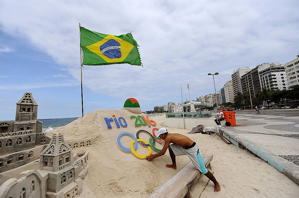 Artista de rua reproduz a logomarca dos Jogos Olímpicos do Rio-2016 nas areias de Copacabana | Vanderlei Almeida/AFP