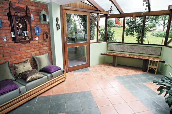 Janelas amplas propiciam iluminação natural e ventilação regular para a casa do arquiteto. Os móveis são de madeira de marcenaria |