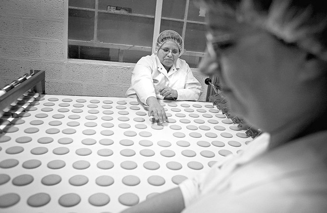 Mulheres trabalham no controle de qualidade em fábrica de biscoitos no Reino Unido |