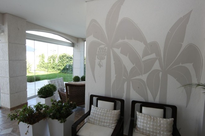 Detalhe tropical na parede da casa da designer Gisele Busmayer. Nesta parede, ela decidiu amenizar o aspecto rústico do grafiato com um desenho personalizado |