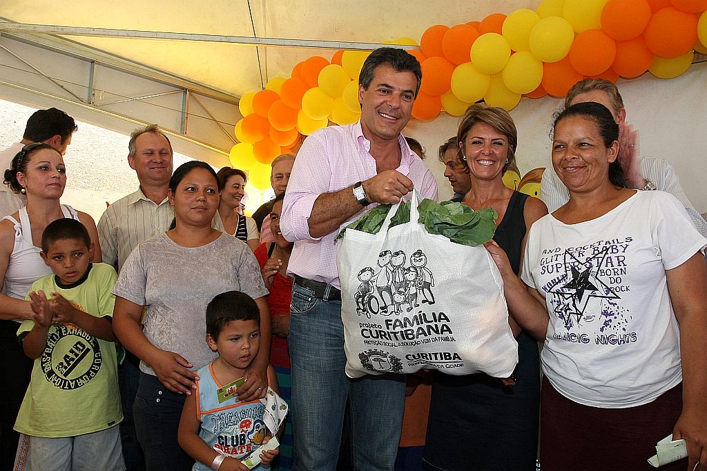 Richa entrega à moradora do Tatuquara uma sacola com alimentos: prefeito nega que programa Família Curitibana seja assistencialista | Orlando Kissner/SMCS