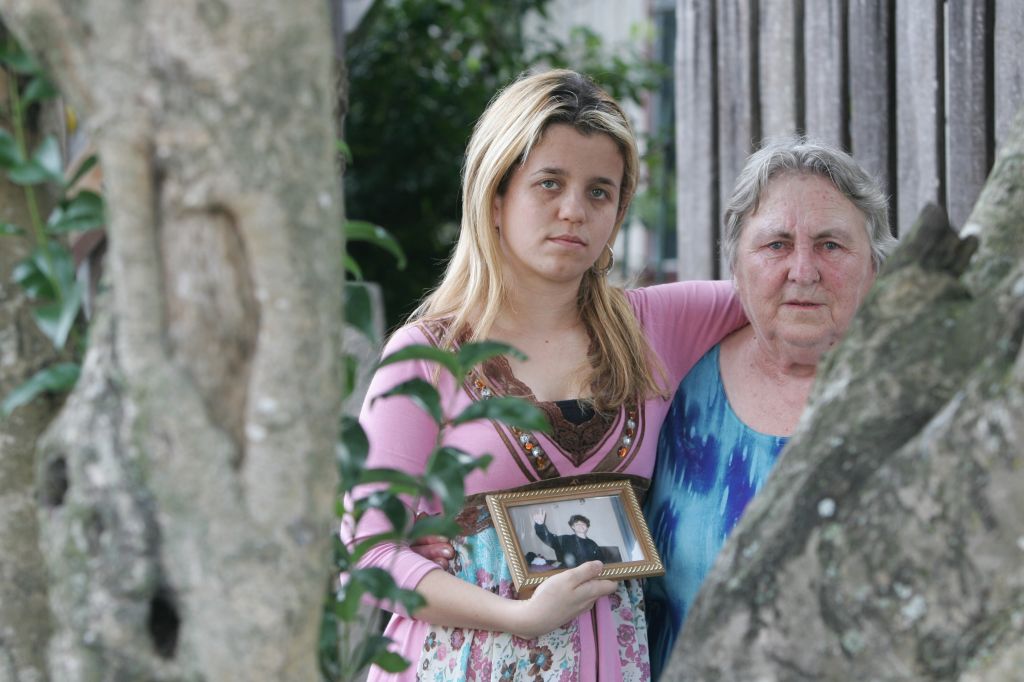 Juliana Molina com a avó, segurando foto do irmão: família sofreu com duas mortes em acidentes de trânsito | Daniel Castellano/Gazeta do Povo