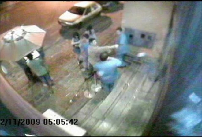 Sem entrar novamente no estabelecimento, ele faz o primeiro disparo |