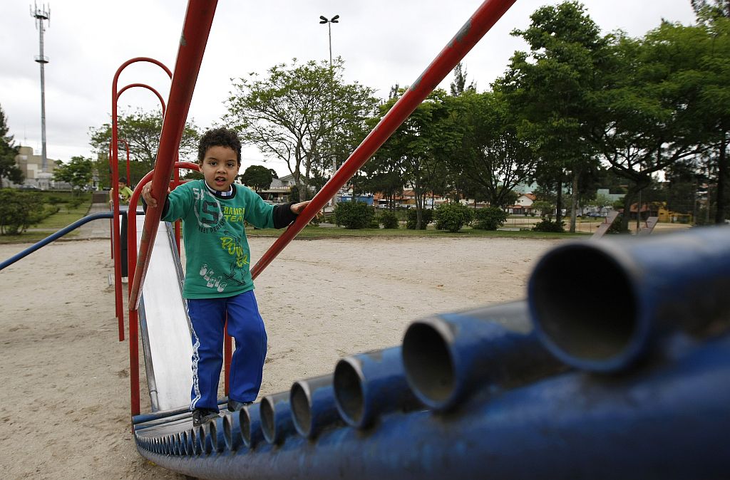 Paulo Vinícius brinca no escorregador de uma parquinho no Hauer: equipamentos quebrados exigem cuidado extra | Rodolfo Bührer/Gazeta do Povo