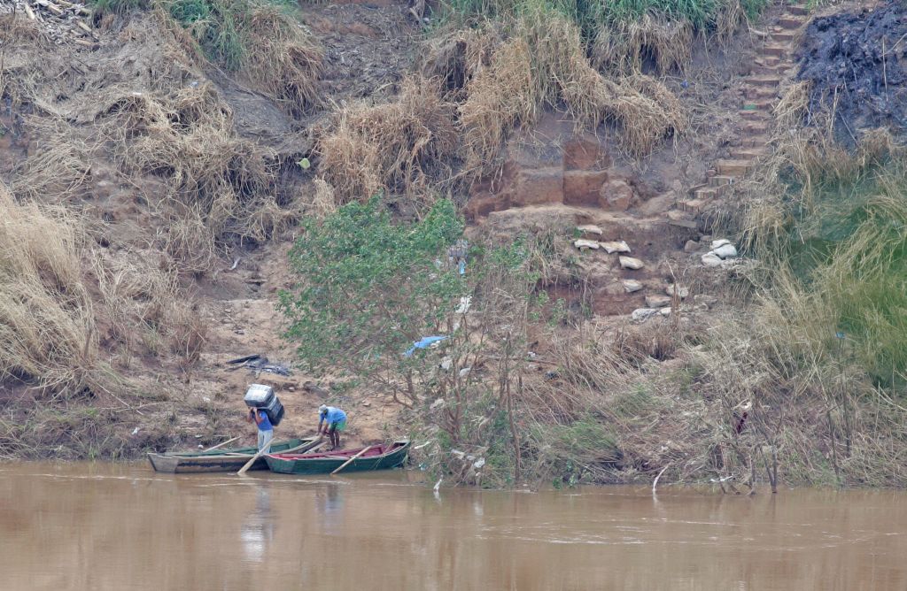 Barranco do Rio Paraná, entre Foz do Iguaçu e Ciudad del Este: homens levam produtos para canoa e, pelo rio, chegam ao Brasil para descarregar mercadoria | Christian Rizzi/Gazeta do Povo