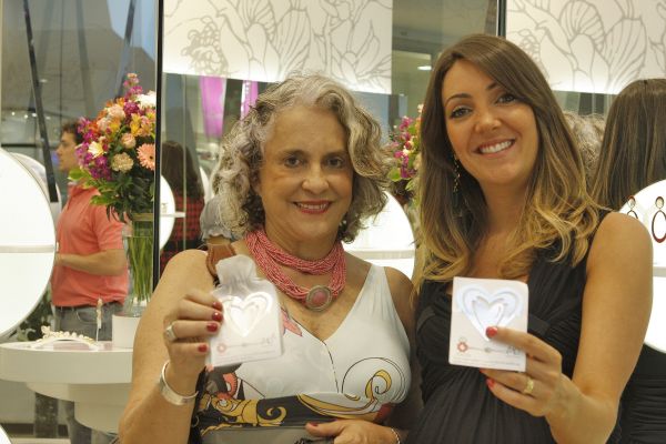 A designer de joias Maria Dolores (à dir.) adotou a Associação dos Amigos do Hospital de Clínicas. Ao comemorar o primeiro ano de sua loja no Shopping Crystal, ela lançou um marcador de páginas cujas vendas reverterão para a entidade, presidida pela advogada Maria Elisa Paciornik (à esq.) | Naideron Jr.