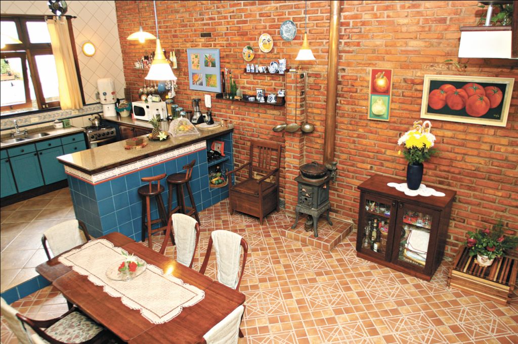 Tijolos de demolição na cozinha do arquiteto Eloy Casagrande Junior. O fogão à lenha garante um aquecimento extra para a casa toda | Fotos: Priscila Forone/Gazeta do Povo