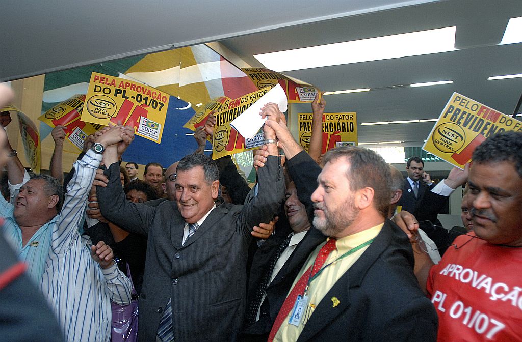 Aprovação do relatório do deputado Arnaldo Faria de Sá (de terno cinza e com os braços levantados) é comemorada por integrantes de entidades de aposentados | Janine Moraes/Agência Câmara