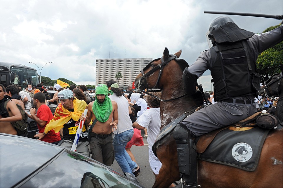 Os policiais da cavalaria bateram com cassetete nos estudantes que estavam no chão em frente ao Palácio do Buriti | AFP