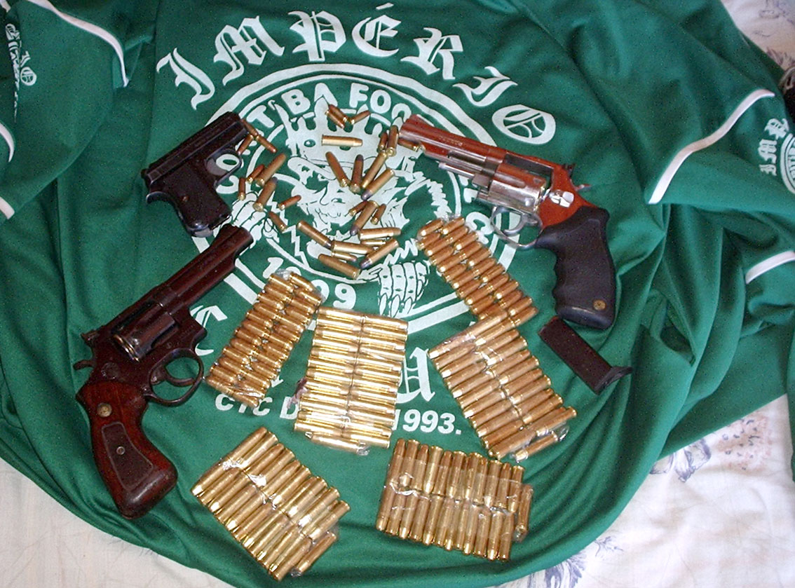 Armas e munição são exibidas sobre camisa da torcida Império | Divulgação / Sesp