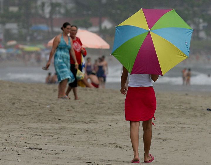 Guarda-sol virou guarda-chuva nas prais nesta quinta-feira, véspera de Natal | Hedeson Alves/Gazeta do Povo