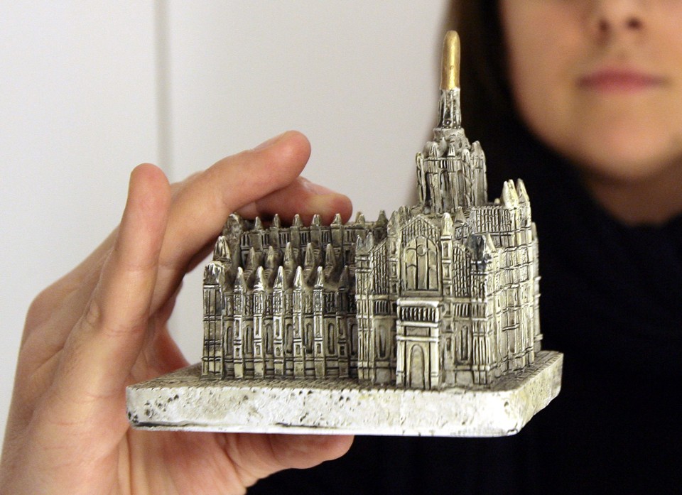 Garota segura uma réplica de catedral semelhante à que foi jogada contra o primeiro-ministro | Alessandro Garofalo/Reuters