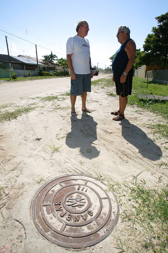 Lorival Antonio da Rosa (esq.) e o vizinho, Perci Berbtz, não terão incômodos nessa temporada com o esgoto | Jonathan Campos/Gazeta do Povo