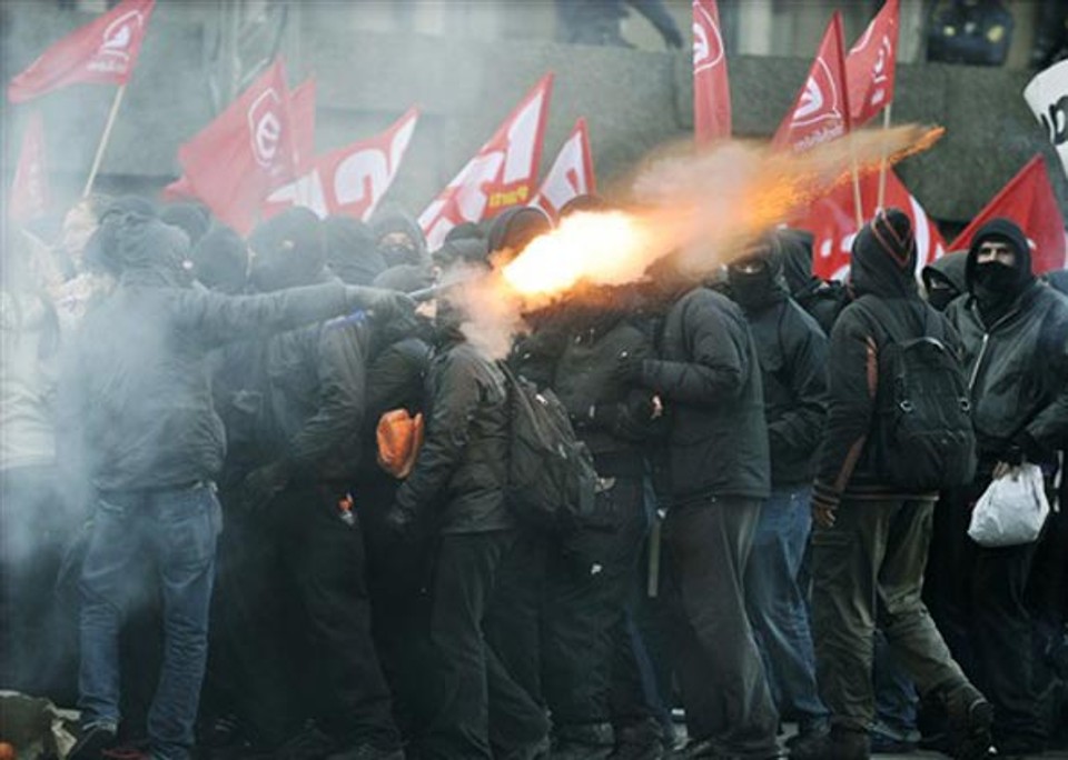 Manifestantes atiram fogos contra policiais durante confronto neste sábado (12) nas ruas de Copenhague, durante a conferência do clima da ONU | AFP