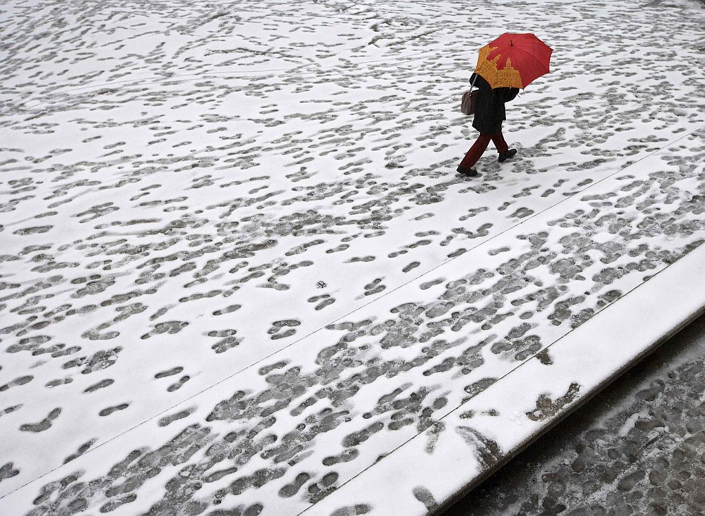 Mulher caminha sobre a neve em Madri, na Espanha. O frio e a neve causaram atrasos em voos e viagens de trem em vários pontos do país | Reuters