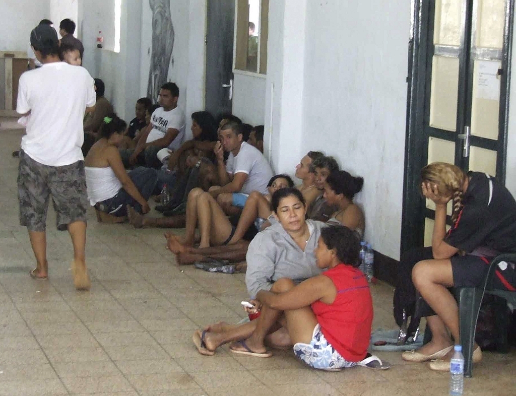 Brasileiros e chineses descansam em local improvisado pelo exército surinamês: relatos de violência sexual e roubos | Hugo Den Boer/Reuters