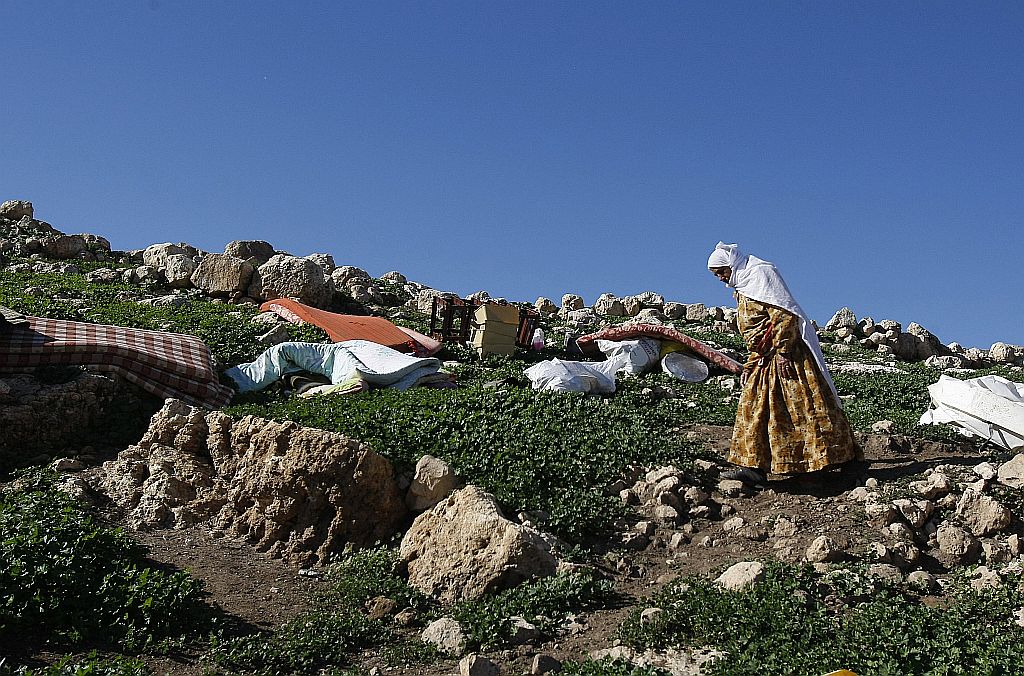 Mulher palestina caminha pelos destroços de sua casa, uma das 20 residências demolidas ontem pelo Exército israelense, deixando cerca de 40 famílias desabrigadas na vila de Tana, controlada por Israel | Jaafar Ashtiyeh/AFP