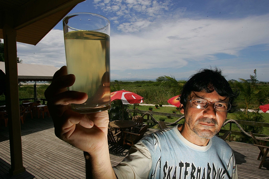 Donizete Rodrigues mostra a água barrenta que sai da torneira: se não chover, problema deve voltar no fim de semana | Jonathan Campos / Gazeta do Povo