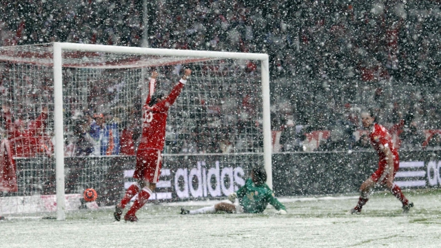 O zagueiro Van Buyten (dir.) comemora o primeiro gol do Bayern: partida chegou a ser interrompida pela neve. | Michael Dalder/ Reuters