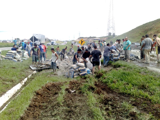 Diversas pessoas coletaram a carga de cimento que caiu do caminnhão que se acidentou na rodovia | 