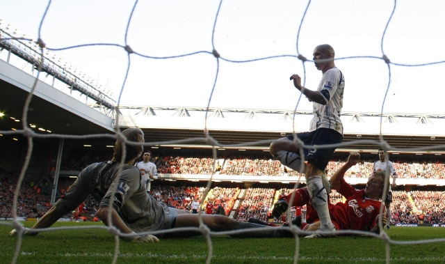 O holandês Dirk Kuyt (de vermelho) supera o goleiro Jaaskelainen para marcar o primeiro gol do Liverpool. | Phil Noble/ Reuters