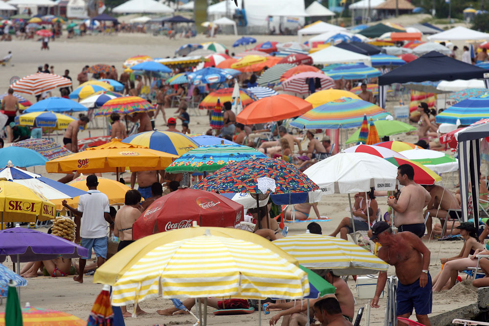As temperaturas elevadas e a sensação de mormaço garantiram a praia neste domingo de céu nublado no Litoral | Hedeson Alves/Gazeta do Povo