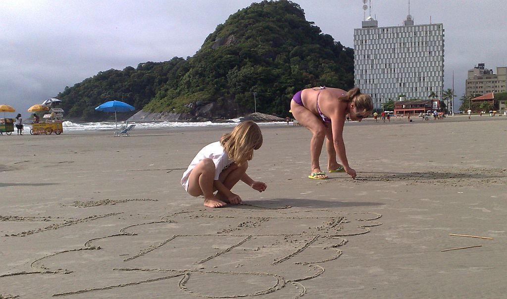 A funcionária pública Ieda Beatriz Fredo brinca na areia de Caiobá com a amiga Fernanda Basso, 7 anos. | Bruna Maestri Walter/ Gazeta do Povo