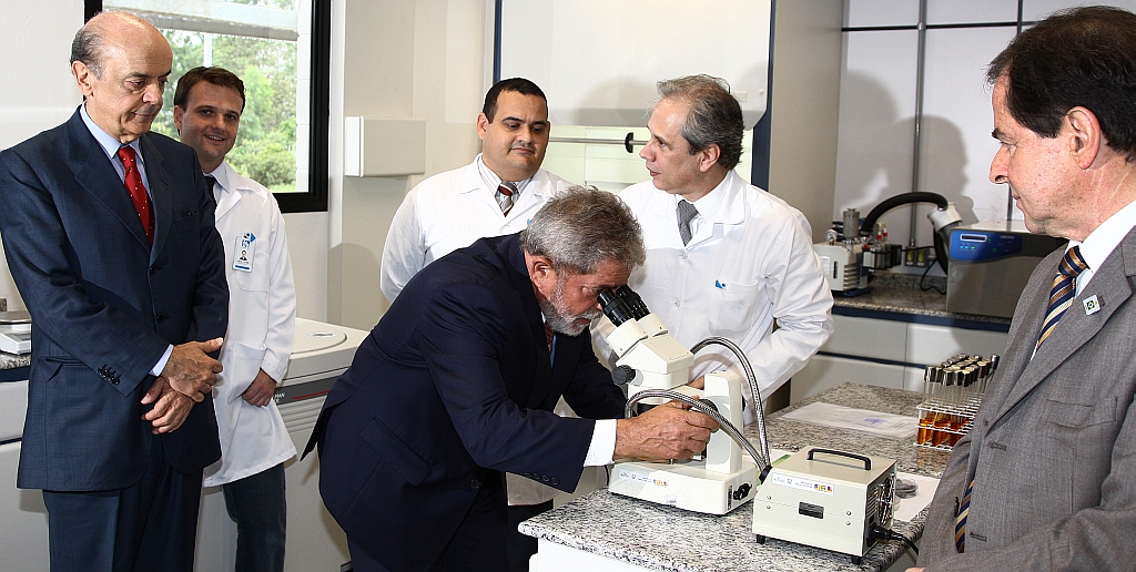 Serra observa Lula olhando em microscópio do Laboratório Nacional do Bioetanol: enquanto seus partidos guerreiam, os dois trocam gracejos | Ricardo Stuckert/Presidência