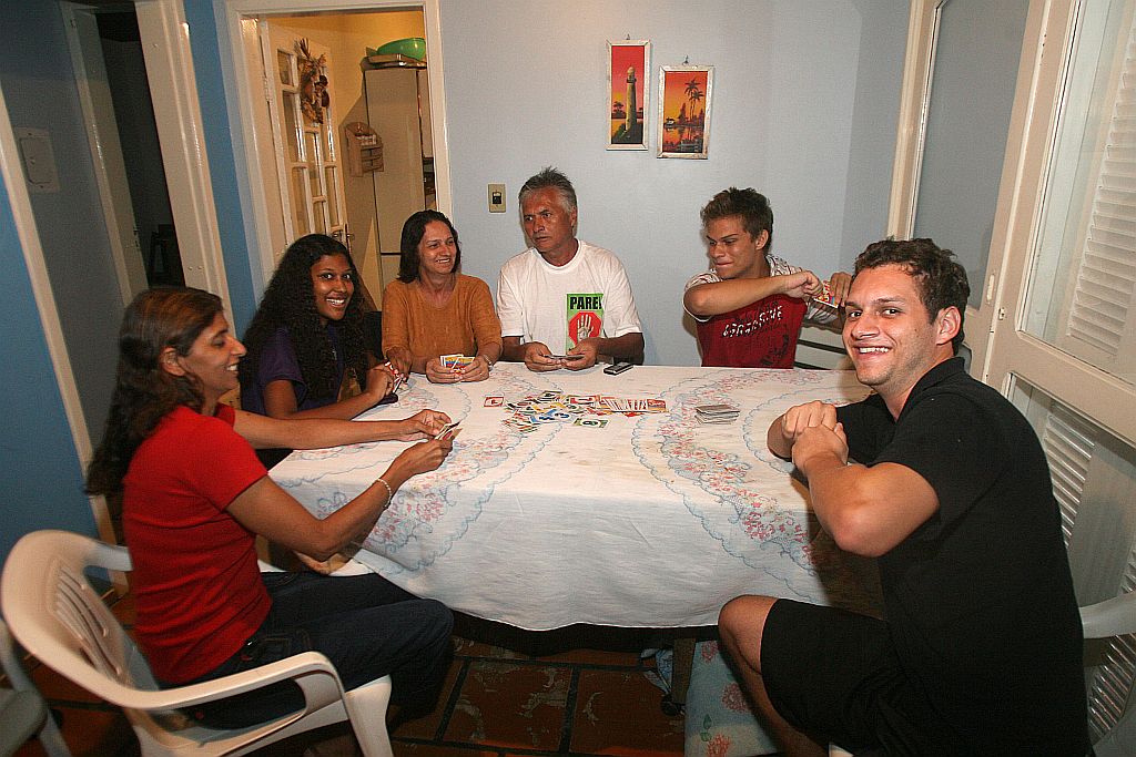 Rotina quebrada: sem poder ir à praia, família de Geraldo Fausto dos Santos (camiseta branca) apelou ao jogo de cartas | Hedeson Alves / Gazeta do Povo