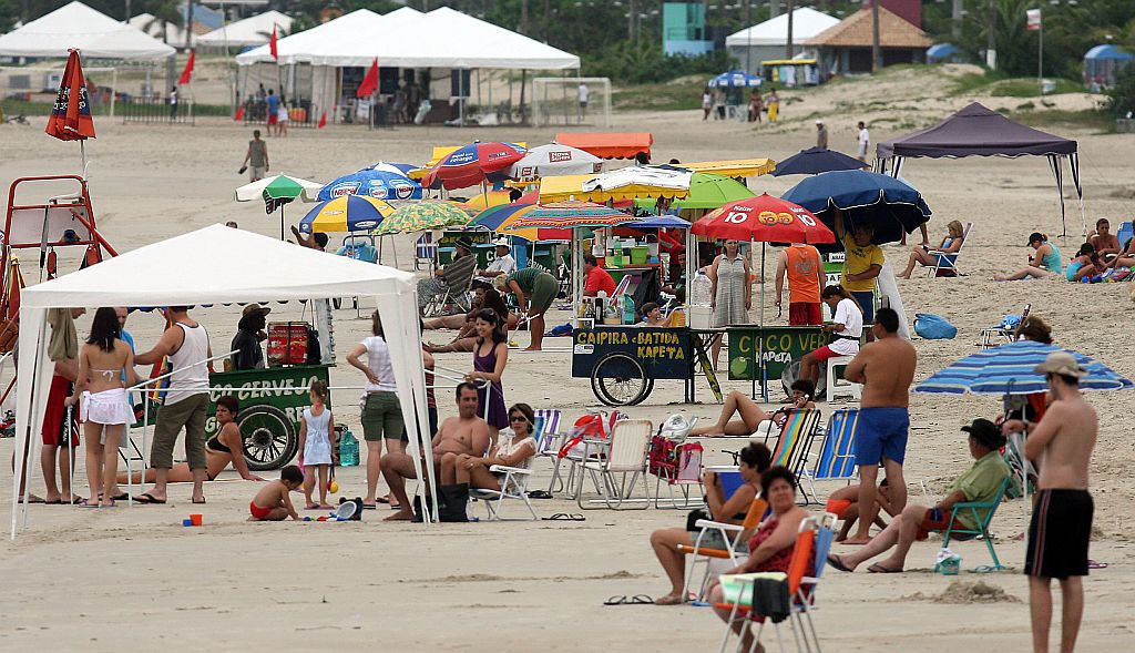 Mesmo sem sol e com temperaturas amenas, os veranistas não deixaram de ir à praia nesta sexta-feira | Hedeson Alves / Gazeta do Povo