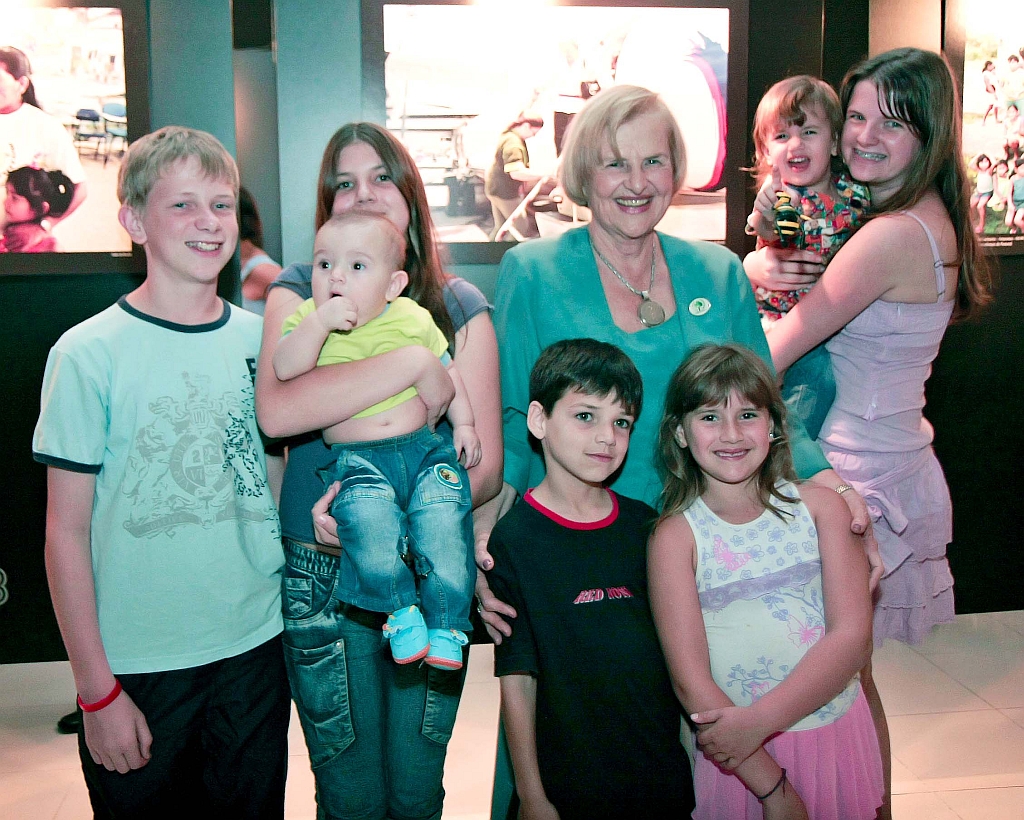 A doutora Zilda Arns numa rara aparição pública ao lado dos netos. A foto foi feita no dia 3 de dezembro de 2007 na abertura da exposição do fotógrafo Jader da Rocha em sua homenagem no Park Shopping Barigui. Ela está acompanhada de sete dos dez netos: Eduard (à esq.); Natali; Gustavo (nos braços de Natali); Danilo (que vinha sendo criado pela avó materna desde a morte da mãe, Sílvia, filha da doutora Zilda, em 2003); Bárbara; Beatriz e Alessandra (com Beatriz nos braços) | Naideron Jr.