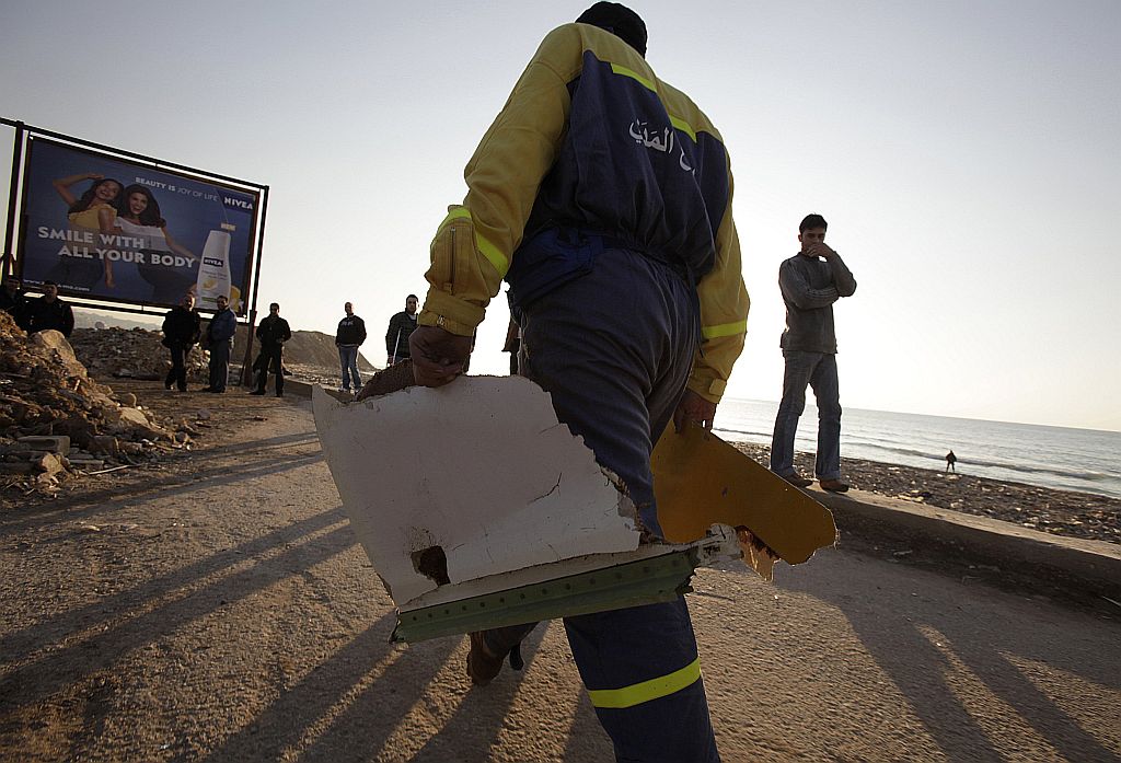 Funcionário da defesa civil libanesa carrega destroços do avião | Reuters