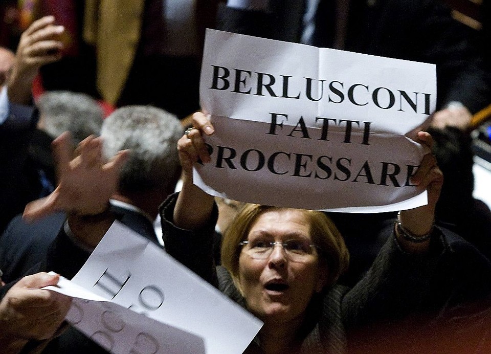 Senadora de oposição Giuliana Carlino segura cartaz dizendo "Berlusconi vá a julgamento" durante votação da lei que pode livrar o primeiro-ministro italiano de dois processos | Reuters