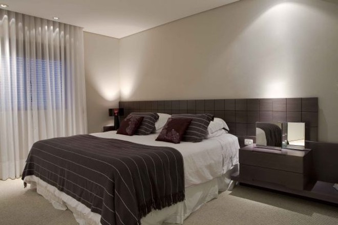 Cabeceira horizontal feita com placa de MDF laminada. O projeto de Carla Kiss custou R$ 2.500 com as mesinhas laterais | 