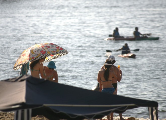 Veranistas aproveitam o dia quente para tomar sol e praticar esportes na água | Daniel Castellano/Gazeta do Povo